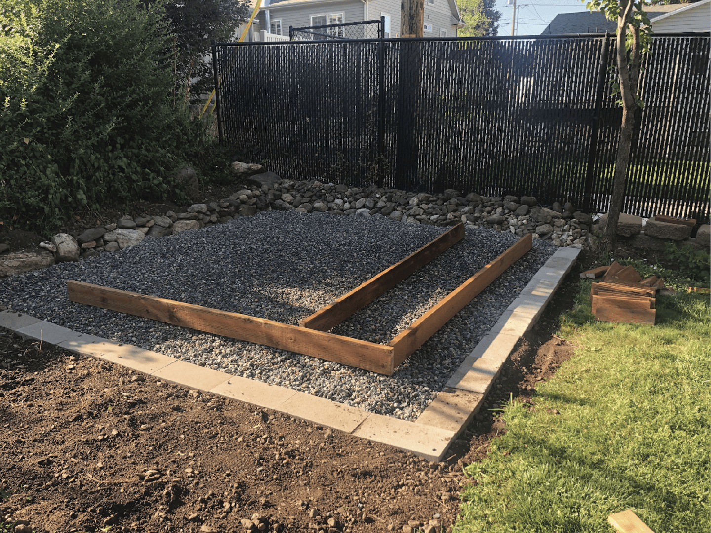 Gravel and timber frame foundation prepared for how to build a garden shed base in a backyard