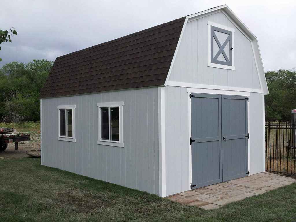 A modern gray farm-style shed with white trim and double barn doors, perfect for backyard storage or workspace needs
