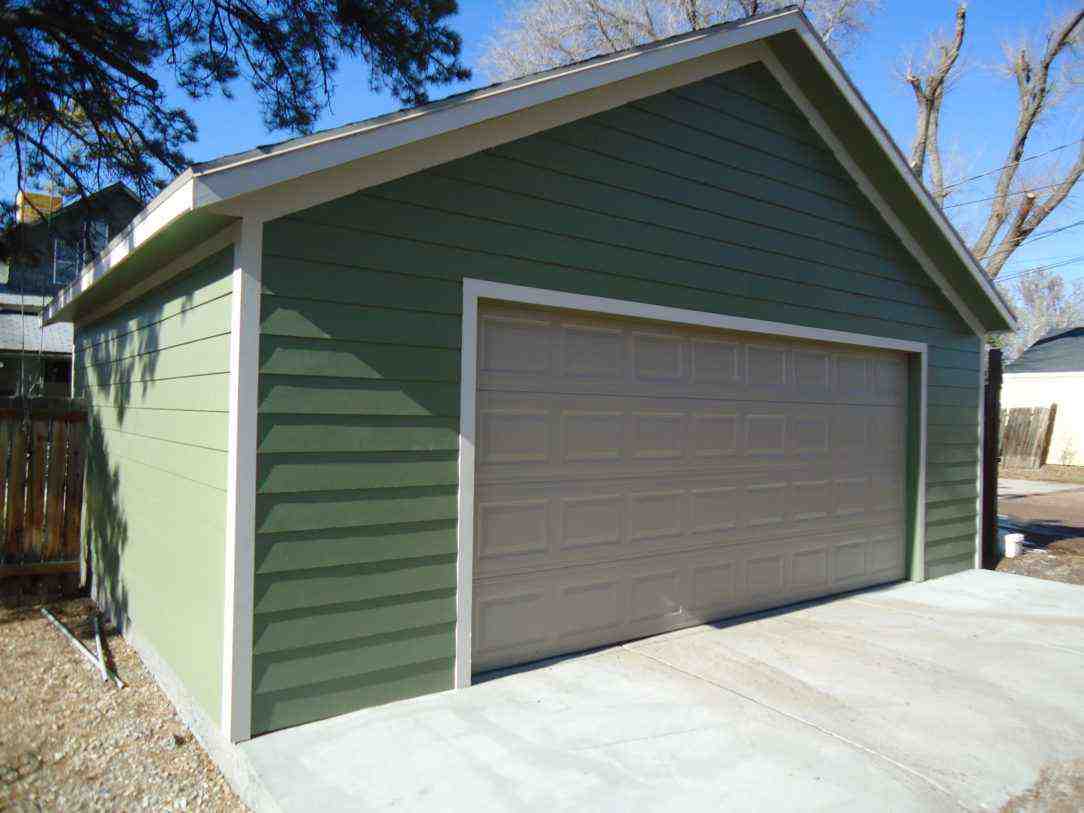 Detached garage with green smooth lap siding and beige garage door, focus keyword siding