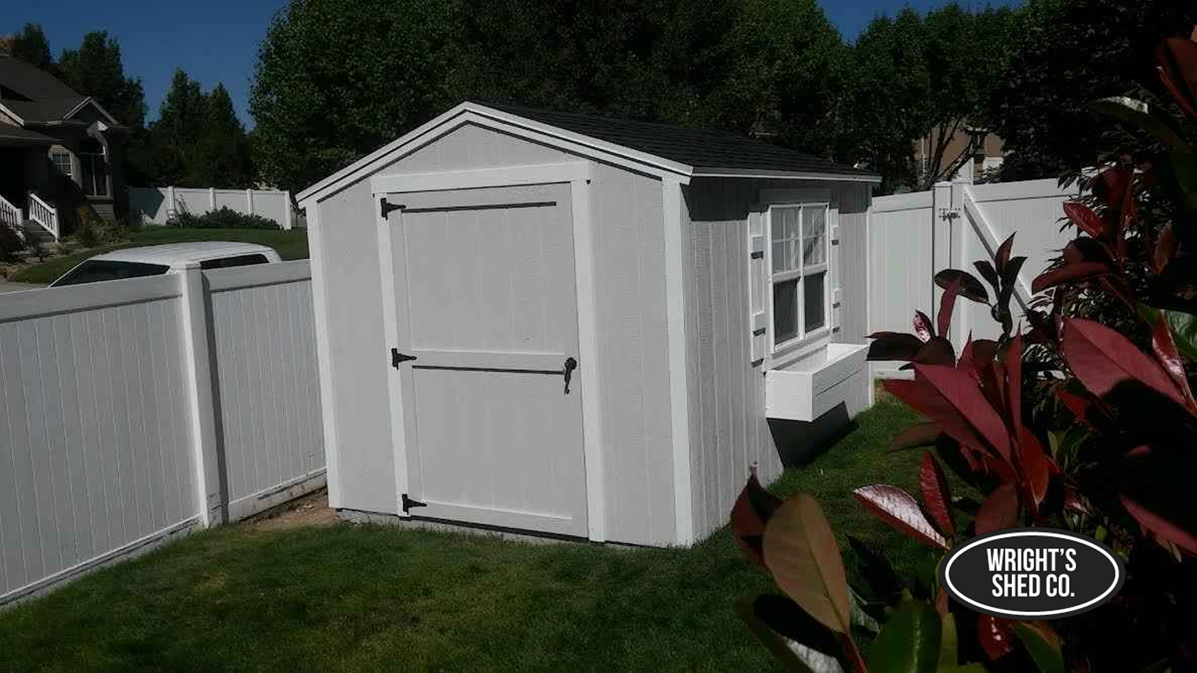 White Wooden Mini Shed in a Private Backyard White wooden mini shed with single door and side windows placed in a fenced backyard, offering compact storage and clean design.