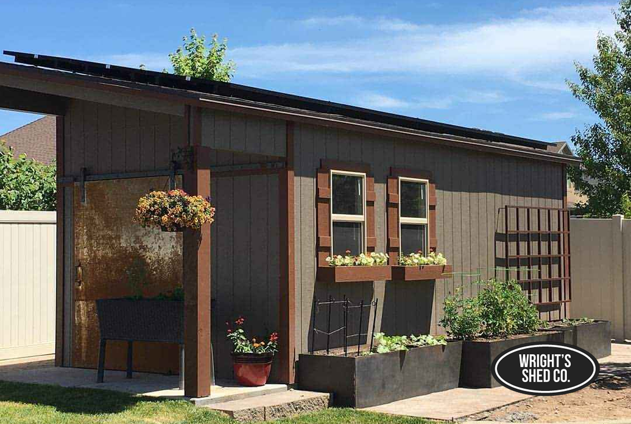 Garden Shed with Planters in Utah Garden-style wood shed in a Utah backyard featuring window planters, raised beds, a trellis, and a shaded seating area built by Wright’s Shed Co.