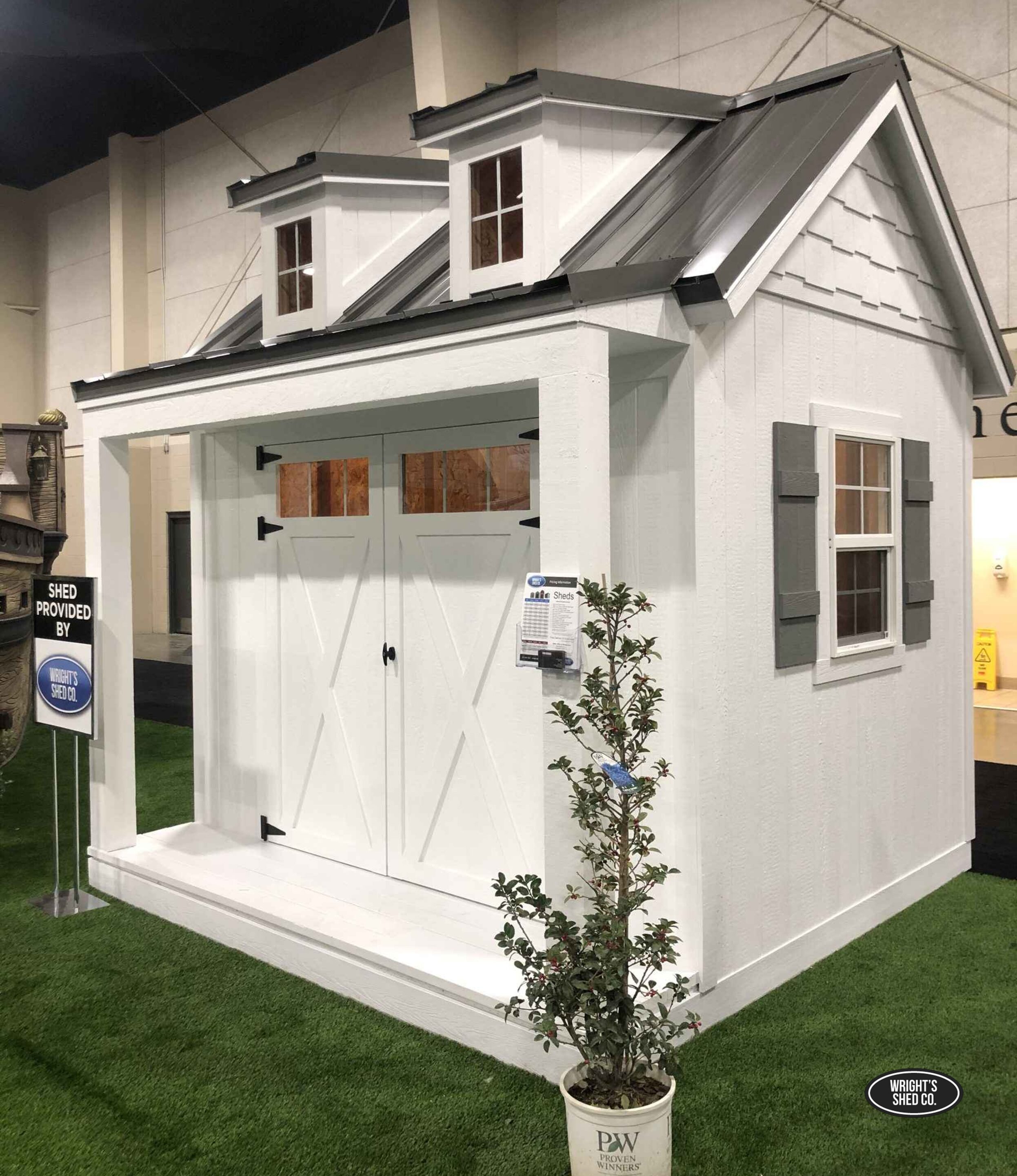 Modern Storage Shed With Dormer and Floor White storage shed with floor and dormer roof on display, featuring double doors, windows, and durable construction for secure, long-term outdoor storage.