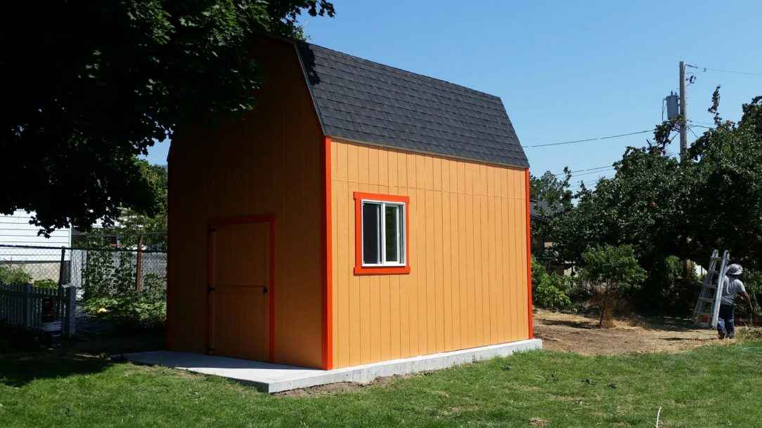 A bright orange shed with red trim and tall walls, serving as an example of functional and stylish outdoor workshop buildings