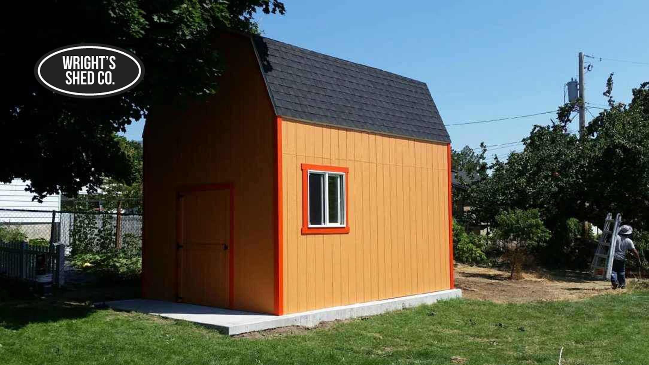 Tall Farm-Style Shed With Gambrel Roof Orange farm-style shed with tall walls, gambrel roof, and window, built on a concrete pad for storage or workshop use.