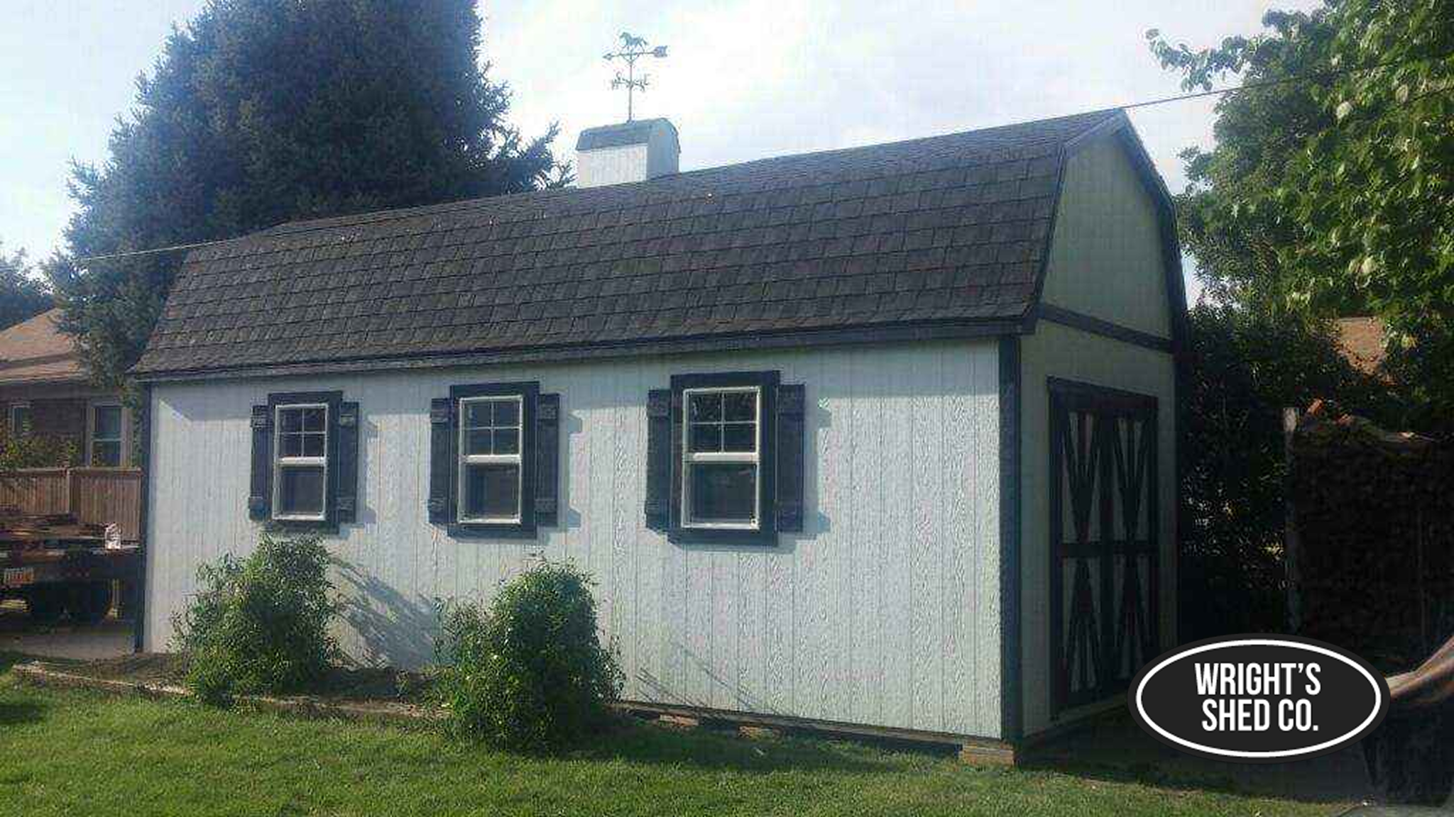 Farm-Style Workshop Shed With Three Windows Farm-style workshop shed with three windows, shake-style roof, and barn doors, offering bright interior workspace and storage.