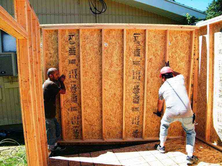 Shed construction materials used in a backyard foundation build with gravel base, framing, and plywood flooring setup ready for shed installation