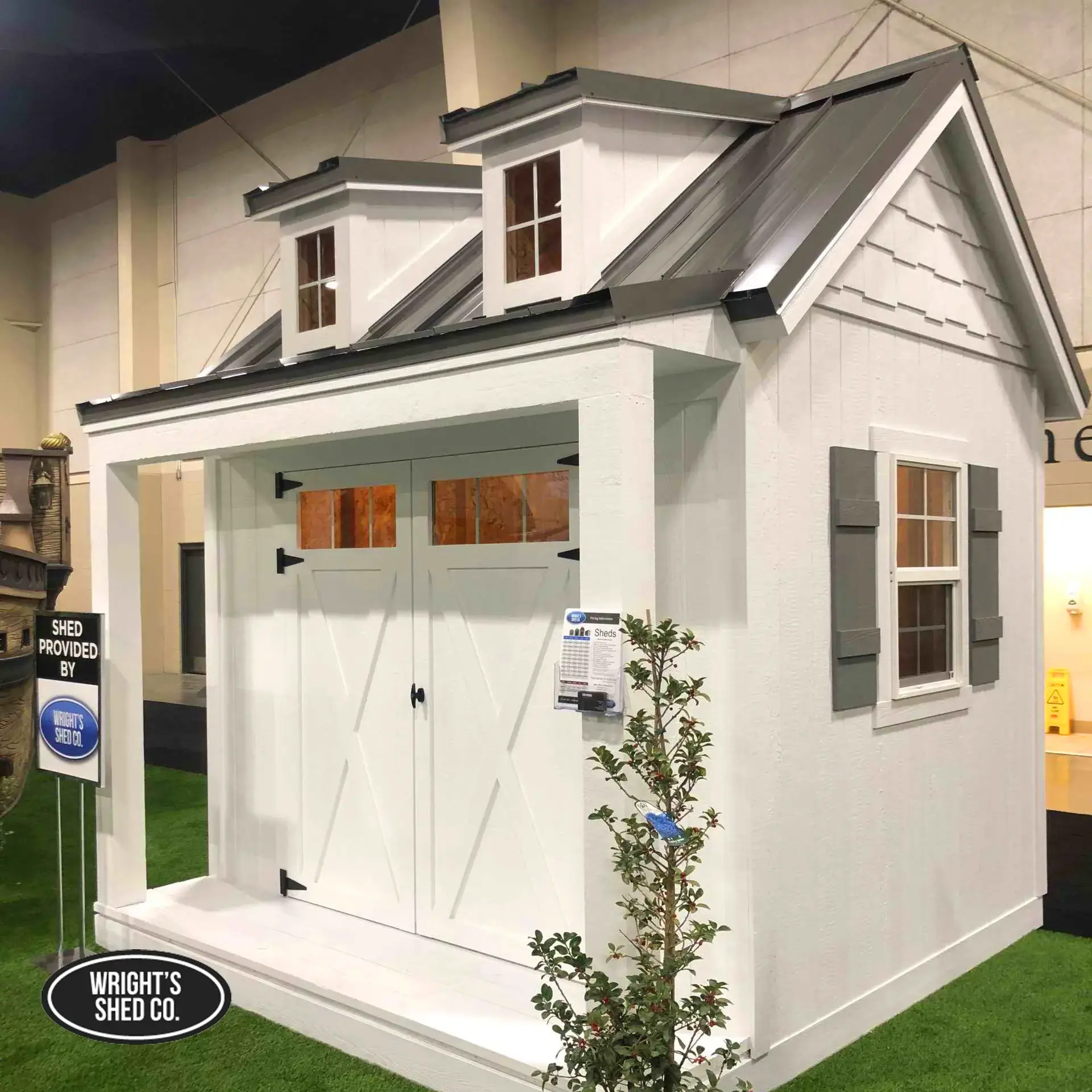 Backyard sauna installation features a compact wood sauna with a dark metal roof outside a commercial workshop.