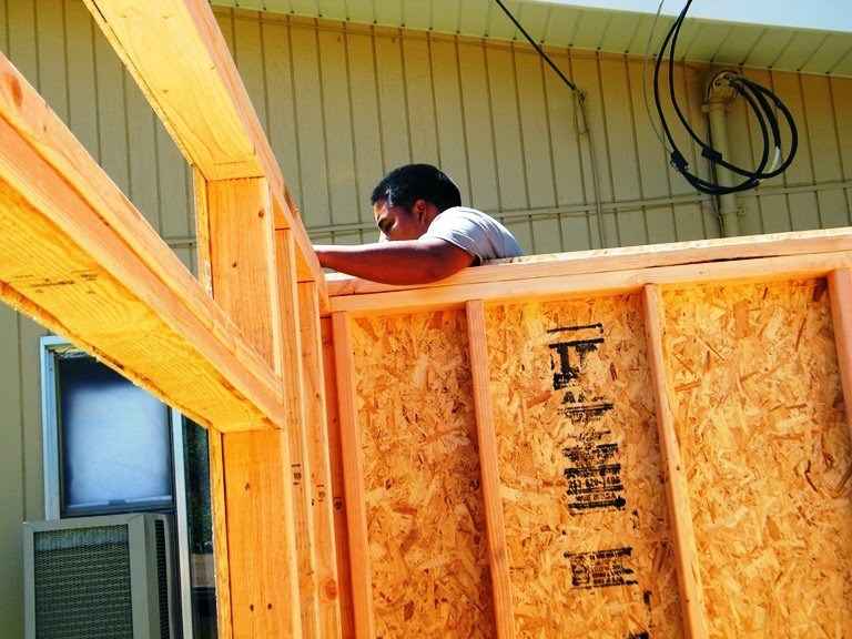 Framing a shed on-site during construction, highlighting local shed builder vs national differences in custom craftsmanship.