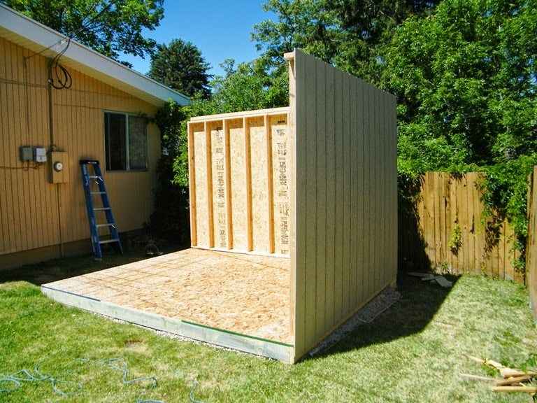 Shed under construction with framed walls and wood flooring, showing how much do shed builders charge for custom builds.