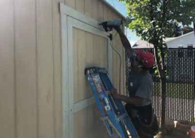 A man holding ladder and fixing the door