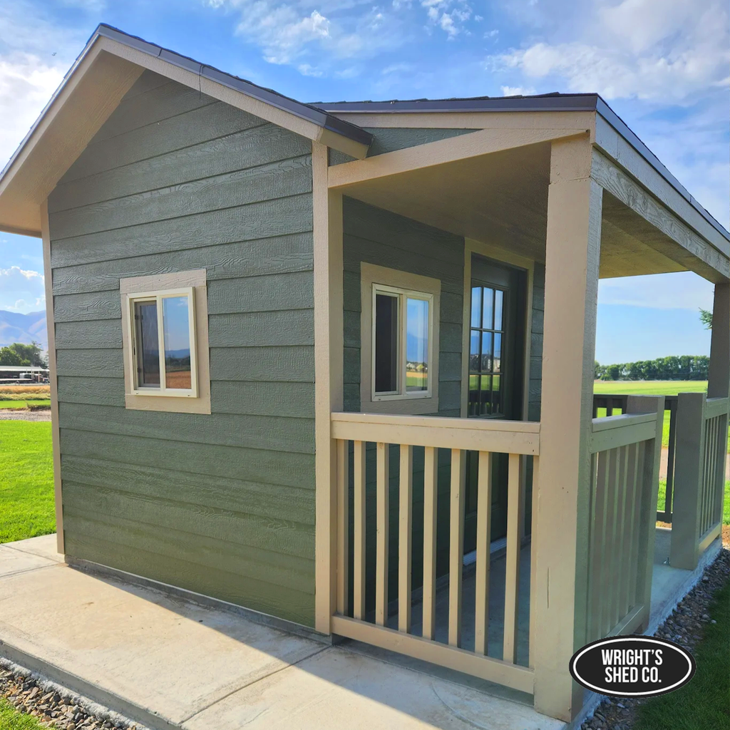 Green shed with covered porch and windows showcasing features that help maximize shed storage and usability.